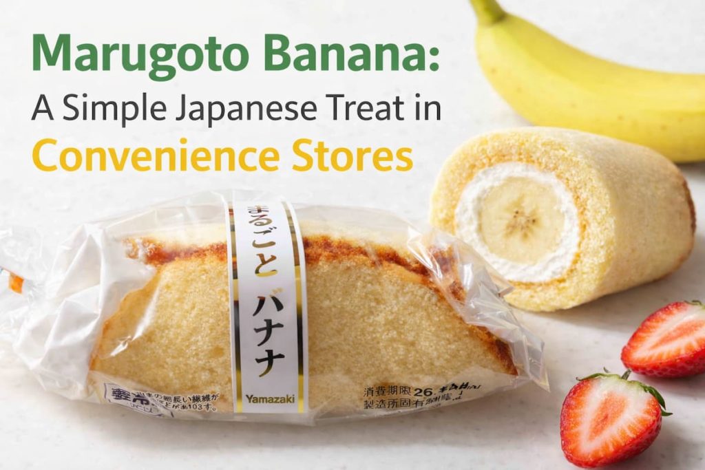 Marugoto Banana cake in its package and a cut piece showing banana and cream inside, with bananas and strawberries, introducing a Japanese convenience store dessert.
